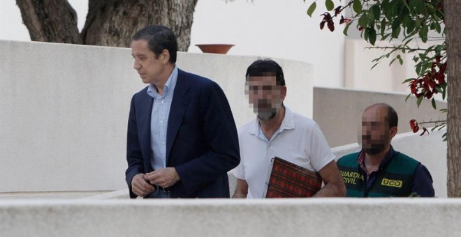 El expresidente de la Generalitat Valenciana y exministro de Trabajo, Eduardo Zaplana, a su llegada a su chalé de Benidorm (Alicante) acompañado por agentes de la UCO de la Guardia Civil. - EFE