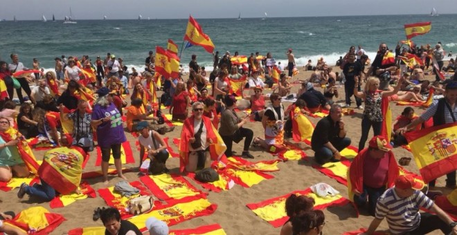 Grup d'unionistes estenen banderes espanyoles a la platja de Barcelona