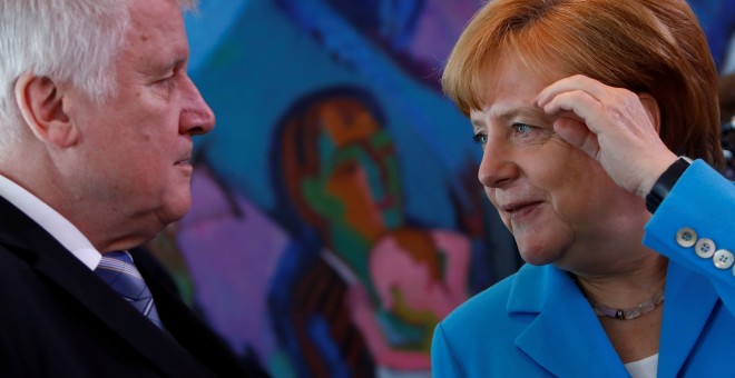La canciller alemana, Angela Merkel, habla con el ministro del Interior, Horst Seehofer, antes de la reunión semanal del gabinete en Berlín. REUTERS / Michele Tantussi