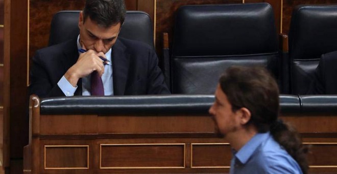 El líder de Podemos, Pablo Iglesias, pasa ante el jefe del Ejecutivo, Pedro Sánchez, durante el pleno del Congreso. (BALLESTEROS | EFE)