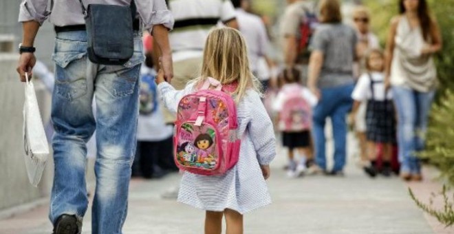 Un padre lleva de la mano a su hija en una calle de Madrid./EFE