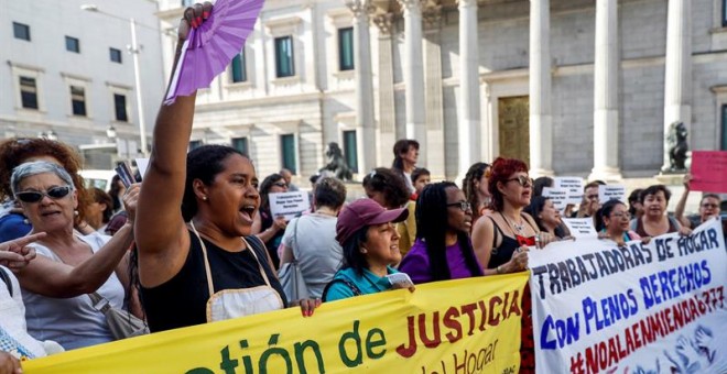Trabajadoras del hogar y cuidados durante la concentración convocada esta tarde frente al Congreso de los Diputados de Madrid para denunciar la enmienda introducida en los presupuestos generales del Estado que retrasa en cinco años la equiparación de las