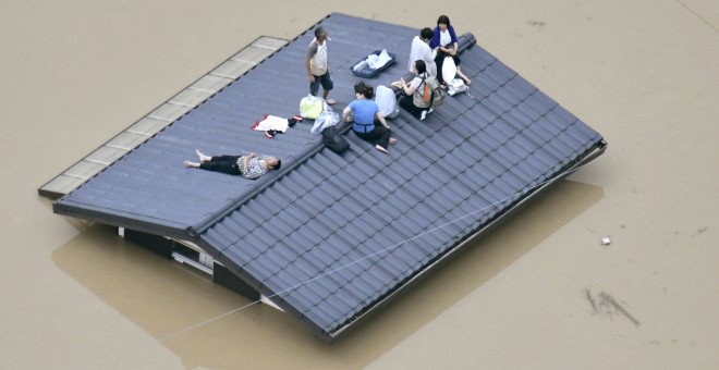 Varias personas esperan encima de un tejado a ser rescatadas, después de las inundaciones provocadas por las lluvias torrenciales de Japón./REUTERS