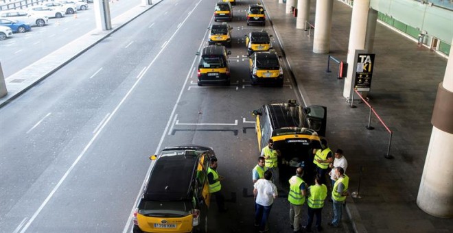 Un grupo de taxistas permanecen parados con sus vehículos en el Aeropuerto de Barcelona durante la huelga de taxis este miércoles. / EFE