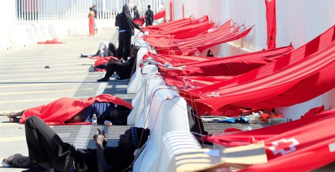 Diversos inmigrantes que permanecen en el puerto de Algeciras desde hace varios, esperan junto a las zonas que ellos mismos han construído para protegerse del sol. Salvamento Marítimo ha rescatado este domingo a 123 inmigrantes de doce pateras que navegab