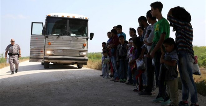 Un grupo de migrantes junto con sus hijos son parados por la Policía en EEUU. REUTERS/Archivo/Loren Elliott