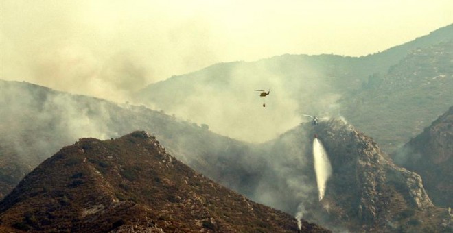 En la imagen dos helicópteros trabajan en el frente del incendio. EFE/Manuel Bruque