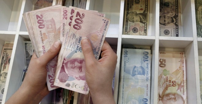 Un cajero cuenta billetes de liras turcas en una oficina de cambio de moneda en Estambul. REUTERS/Murad Sezer