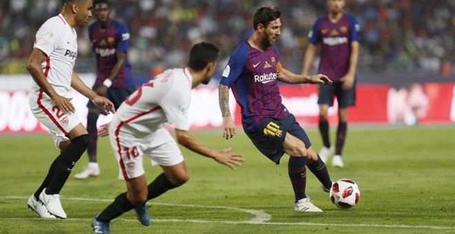 El delantero argentino del FC Barcelona Leo Messi (d) juega un balón ante Jesús Navas (c) y Gabriel Mercado, ambos del Sevilla, durante la Supercopa. EFE