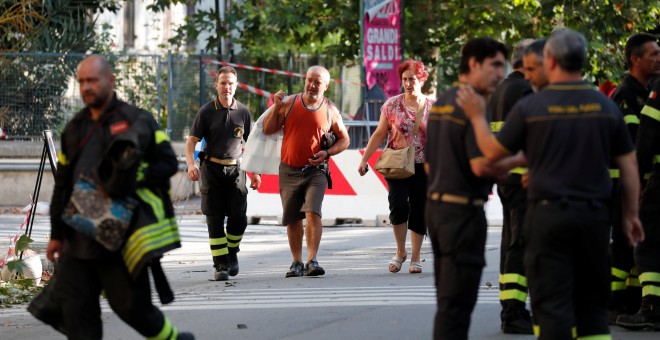 Los bomberos ayudan a los residentes de las viviendas junto al puente derruido en Génova a recoger sus pertenencias. REUTERS/Stefano Rellandini