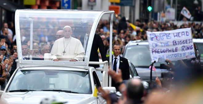 Francisco, en el Papamóvil, pasa junto a una pancarta de protesta contra los abusos a menores de la Iglesia. - REUTERS