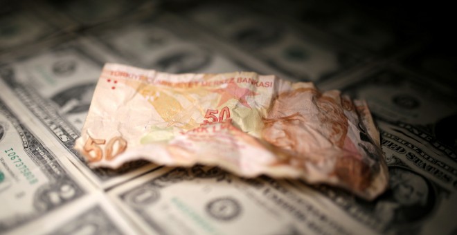 Un billete de 50 liras turcas, sobre varios dólares. REUTERS/Dado Ruvic