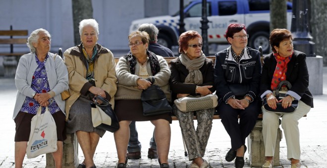 Varias mujeres mayores sentadas en un banco en el pueblo burgalés de Briviesca.  AFP/César Manso
