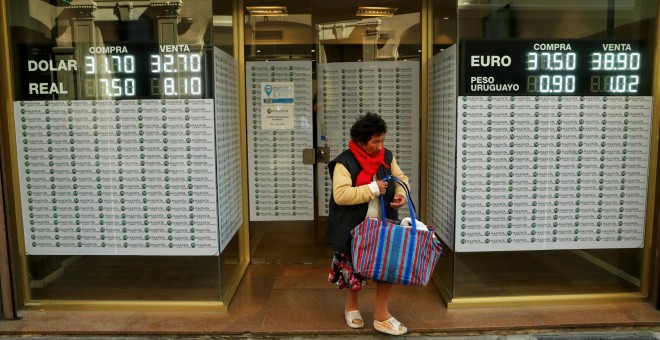 Una mujer sale de una oficina de cambio de moneda en el distrito financiero de Buenos Aires. REUTERS/Marcos Brindicci