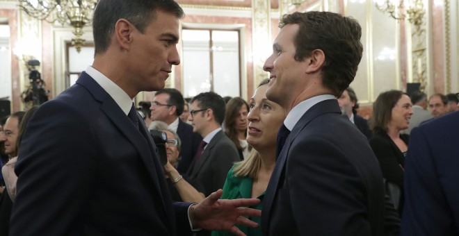 El presidente del Gobierno, Pedro Sánchez, conversa con el líder del PP, Pablo Casado, en presencia de la presidenta del Congreso, Ana Pastor, en el Salón de los Pasos Perdidos poco antes de la presentación de los actos conmemorativos del cuarenta anivers