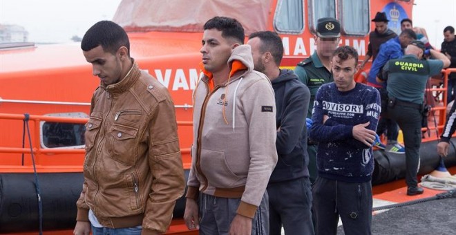 Efectivos del Servicio Marítimo de la Guardia Civil custodian a 15 personas de origen marroquí, entre ellos un menor, que han sido rescatado de una patera y trasladados al puerto de Motril. EFE/Paquet