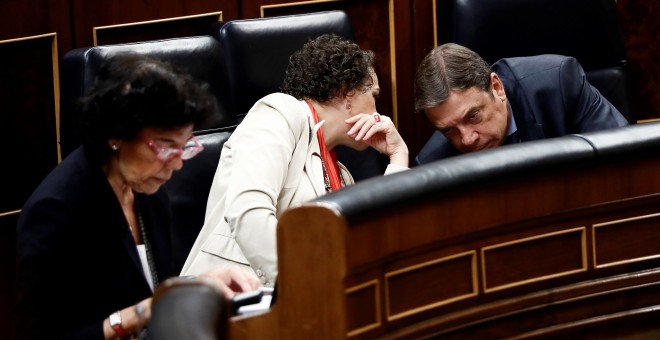 La ministra de Trabajo, Magdalena Valerio, conversa con el de Agricultura, Luis Planas, durante la sesión de control al Gobierno en el Congreso de los Diputados. EFE/Mariscal