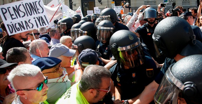 Grupos de pensionistas que se concentraron en el Congreso de los Diputados pidiendo mejoras en sus prestaciones intentan romper el cordón policial intentaba impedir su paso hasta la Cámara. REUTERS/Stringer