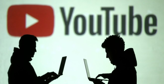 Logo de YouTube tras la silueta de dos usuarios. REUTERS/Dado Ruvic