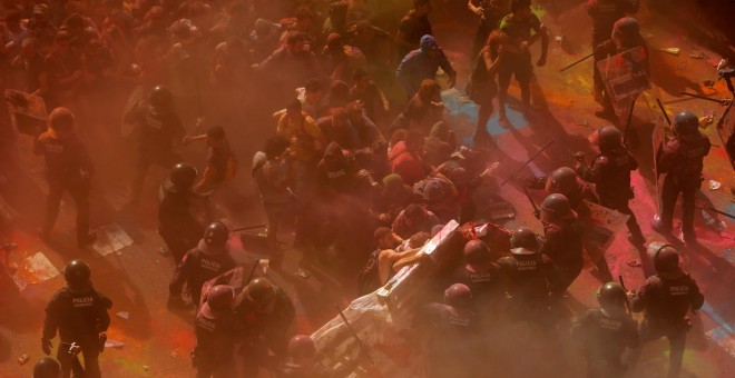 Imagen de los independentistas lanzando pintura a los Mossos de Esquadra.| Jon Nazca / Reuters