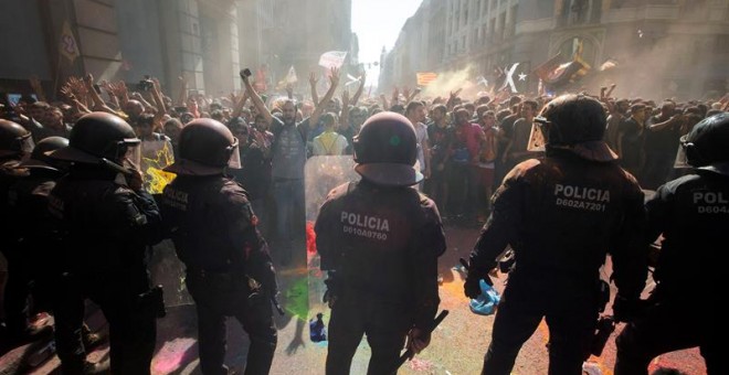 Los Mossos d'Esquadra instantes después de ser rociados con pintura en polvo. | Marta Pérez / EFE
