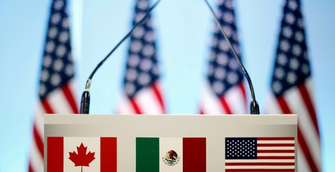 El atril adornado con las tres banderas que representan a los países del nuevo acuerdo USMCA - Reuters/Edgard Garrido