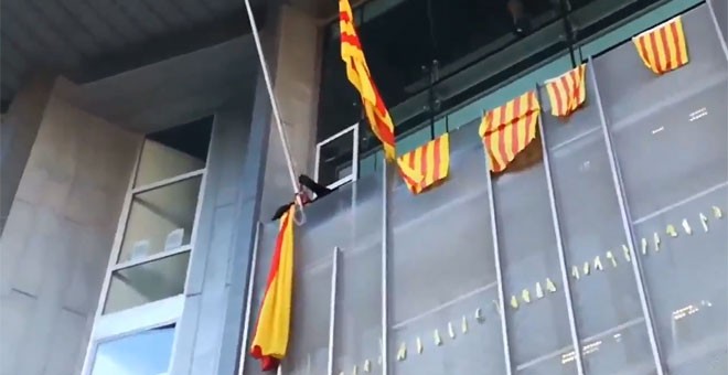 Momento en el que un grupo de los CDR retira la bandera española en la Delegación de la Generalitat en Girona