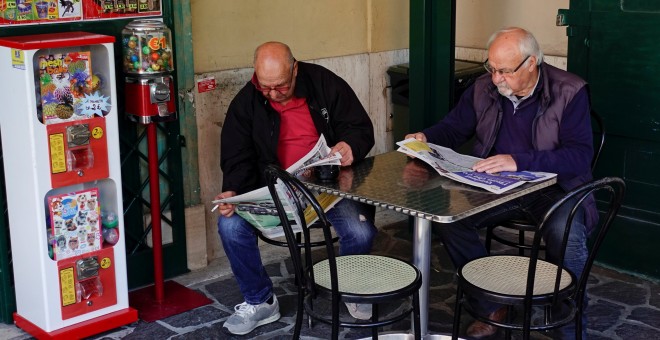 Dos pensionistas leen la prensa en un bar en Roma. REUTERS/Max Rossi