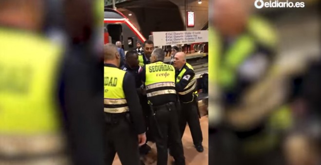 Captura del vídeo publicado por 'eldiario.es' del momento en el que el joven negro es sacado del tren y reducido en el andén tras negarse a mostrar su billete.- ATLAS
