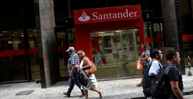 Varias personas pasan por delante de una sucursal de Banco Santander en el centro de Rio de Janeiro (Brasil). REUTERS/Ricardo Moraes
