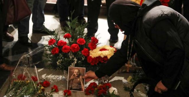 Una mujer coloca una foto de Franco sobre su tumba en el Valle de los Caídos. (REUTERS)