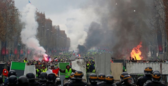 Miles de manifestantes se enfrentan a la Policía en los Campos Elíseos de París durante la manifestación de los 'chalecos amarillos'.-REUTERS/Gonzalo Fuentes