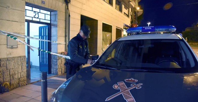 Un agente de la Guardia Civil acordona la entrada a la vivienda donde una mujer ha sido asesinada presuntamente por su expareja, en Monzón, Huesca.- EFE