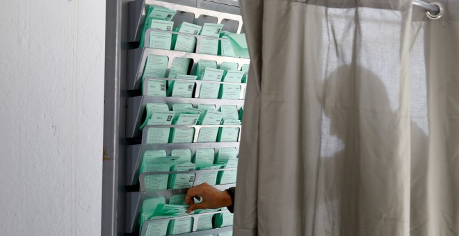 2/12/2018. Un hombre coge su papeleta antes de emitir su voto en las elecciones andaluzas en un colegio de Sevilla. REUTERS/Marcelo del Pozo