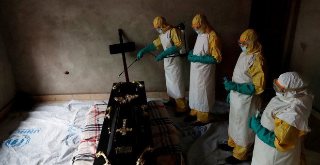 Un equipo médico desinfecta una habitación durante un funeral de un sospechoso de haber muerto por ébola - REUTERS/Goran Tomasevic