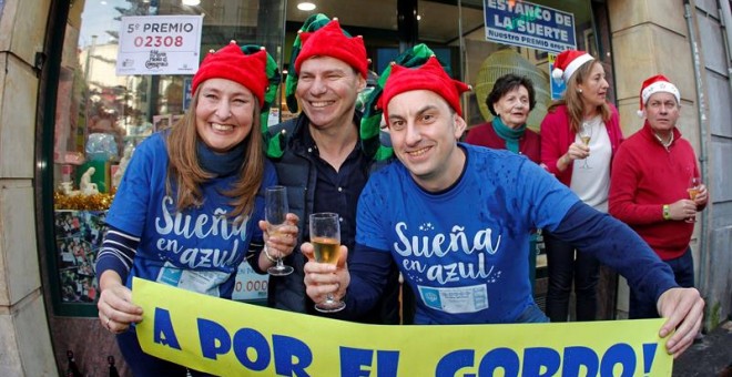 En Oviedo han sido vendidos tres décimos del Gordo en un despacho situado en el número 8 de la calle Jovellanos, en la imagen, los administradores lo celebran en la puerta del local.. /EFE