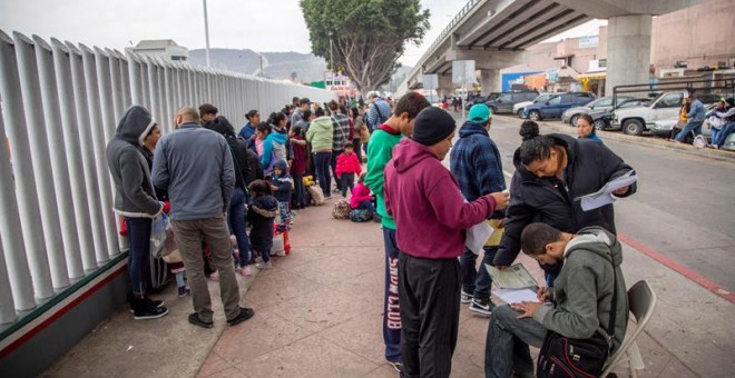 Un grupo de migrantes venezolanos, guatemaltecos, hondureños y mexicanos esperan para iniciar la solicitud de visa humanitaria hoy, afuera de la oficina fronteriza estadounidense de El Chaparral, en la frontera de la ciudad de Tijuana, en el estado de Ba