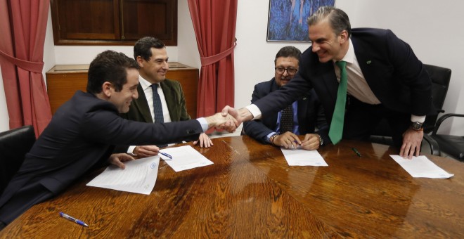 Los secretarios generales del PP, Teodoro García Egea (i), y de Vox, Francisco Javier Ortega Smith (d), estrechan las manos en presencia de los líderes andaluces del PP, Juanma Moreno (2i) y de Vox, Francisco Serrano (2d), durante la reunión en el Parlame
