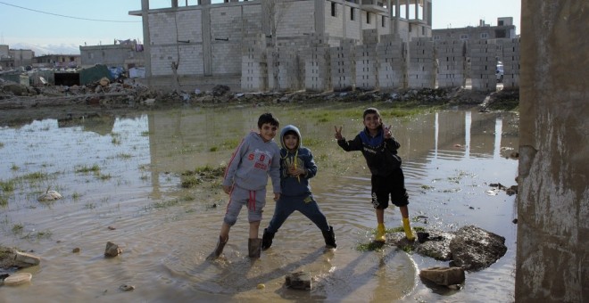 Niños juegan en los charcos dejados por las fuertes lluvias./Andrea Olea