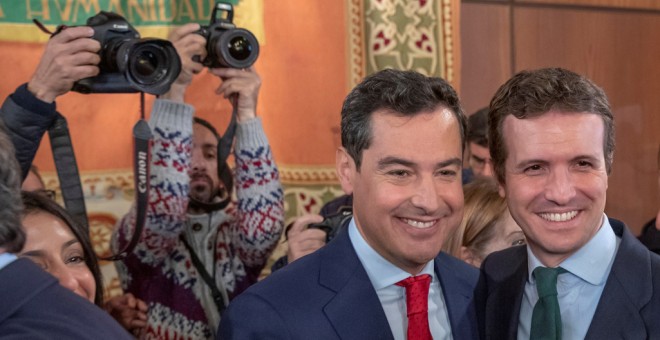 El nuevo presidente de la Junta de Andalucía, Juanma Moreno, es felicitado por el presidente del PP, Pablo Casado, tras el acto de toma de posesión de su cargo en el Parlamento andaluz. EFE/Julio Muñoz