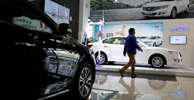 Un hombre camina en un concesionario de automóviles eléctricos en Shanghai. REUTERS / Aly Song