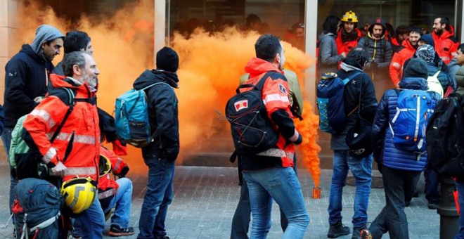 Diversos bombers llencen petards i bengales a l'entrada de la conselleria d'Interior on s'han dirigit desenes de treballadors que es manifesten des de la primera hora del matí pel centre de Barcelona davant la 'manca de resposta' a les demandes laborals p