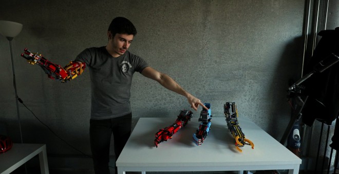 David Aguliar points at his prosthetic arms built with Lego pieces during an interview with Reuters in Sant Cugat del Valles, near Barcelona, Spain, February 4, 2019. Picture taken February 4, 2019. REUTERS/Albert Gea
