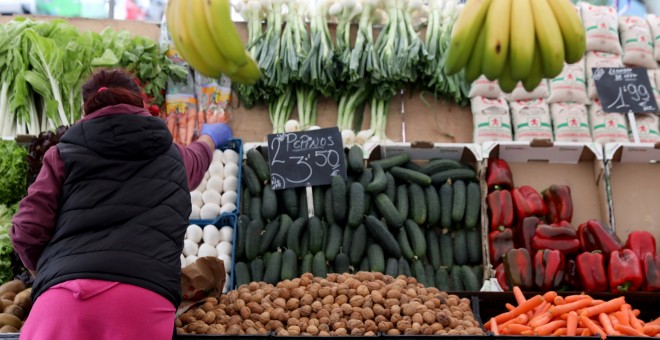 Una vendedora en una tienda de rutas y verduras en un mercado de Madrid. REUTERS/Sergio Perez