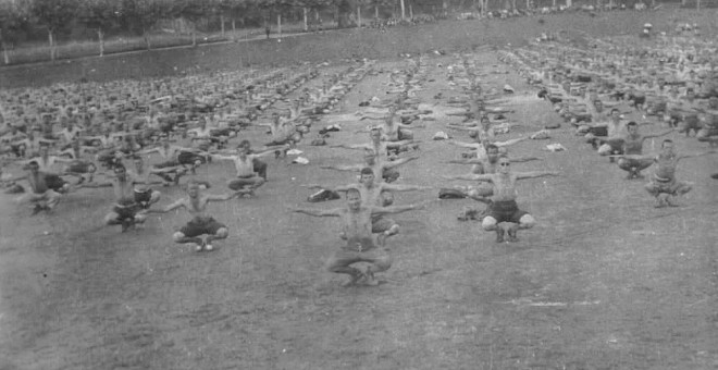 Prisioneros del campo de concentración instalado en las caballerizas del Palacio de La Magdalena (Santander) haciendo gimnasia. La sesión fue preparada para tomar fotografías de cara a un reportaje elaborado por el servicio de propaganda franquista.- BIBL