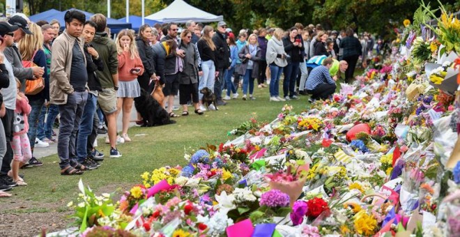 Members of the public visit at a makeshift memorial for the victims of the mosque mass murders at the Botanical Gardens in Christchurch, New Zealand, 17 March 2019. A gunman killed 50 worshippers at the Al Noor Masjid and Linwood Masjid on 15 March. A sus