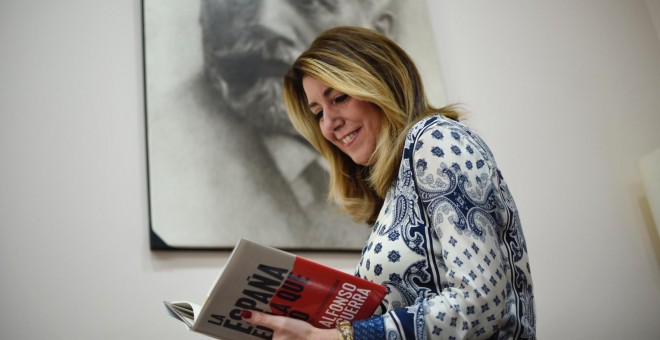Susana Díaz lee el libro de Alfonso Guerra, delante de un retrato de Pablo Iglesias, fundador del PSOE