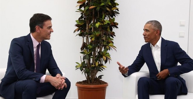 El presidente del Gobierno español, Pedro Sánchez, conversa con el expresidente de Estados Unidos, Barack Obama./EFE