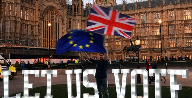 Un manifestante anti-Brexit ondea banderas frente a las Casas del Parlamento en Londres, | Reuters