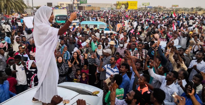 Alaa Salah, una mujer sudanesa con sus poderosos cantos de protesta contra Al-Bashir, se dirige a los manifestantes frente a la sede militar en la capital, Jartum, el 10 de abril de 2019 | AFP